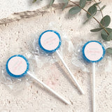 Mini lollipops with blue lollipop tops, wrapped in clear plastic on white sticks.