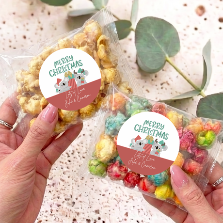Clear Christmas popcorn bags with koala sticker, held in hands