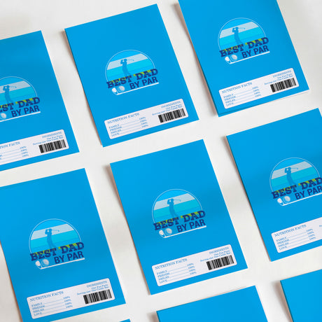 Multiple blue “Best Dad By Par” chocolate wrappers with nutrition facts and barcodes