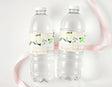 Christening water bottle labels on two clear bottles, white floral design with green cross