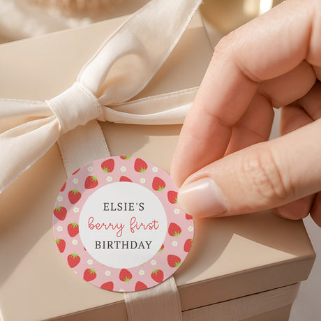 Round berry first birthday label with strawberry pattern and name “Elsie’s”