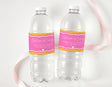 Personalised wavy water bottle labels in pink and orange on clear plastic bottles