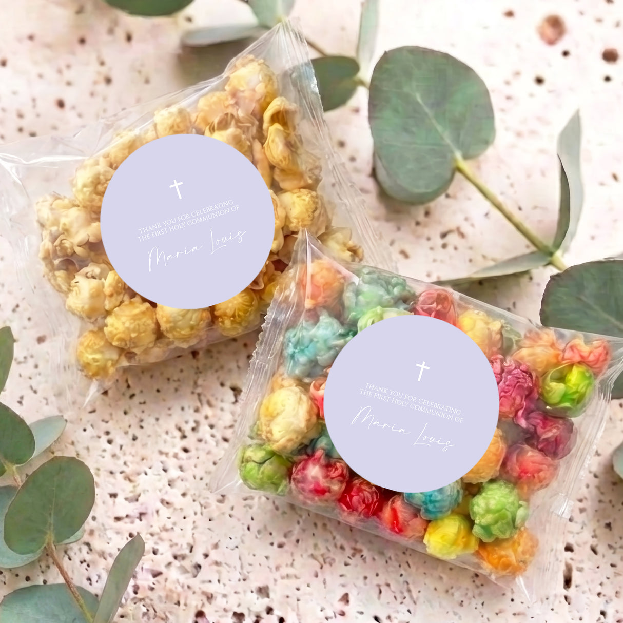 Two personalised popcorn bags with colorful popcorn in clear bags, cross circle labels