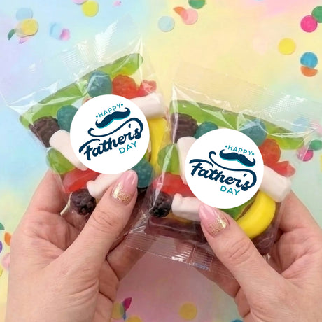 Two Happy Fathers Day party mix lolly bags in clear wrap held in hands