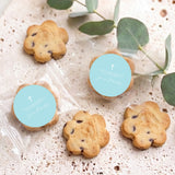 Blue round cookie seals with white cross, surrounded by small baked cookies
