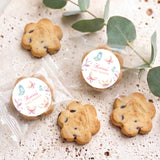 Assorted bite-size cookies with round pastel butterfly labels for baby shower