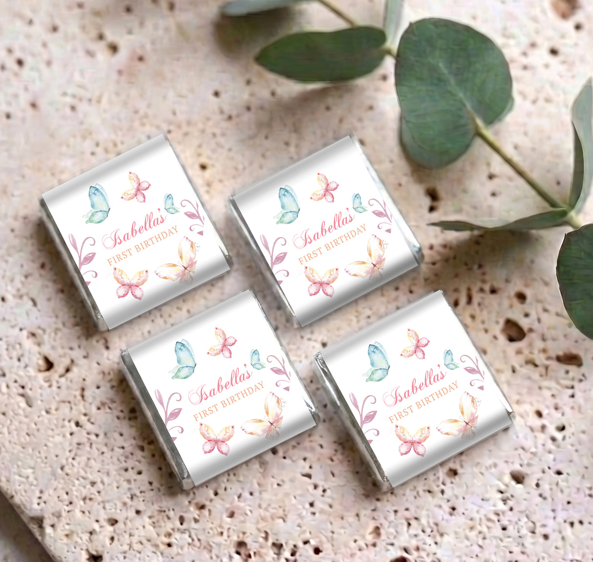 Set of mini chocolate wrappers with pastel butterflies and 'Isabella' 'First Birthday'