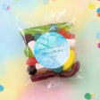 Personalised lolly bag with round blue label and mixed candy lollipops in clear pouch