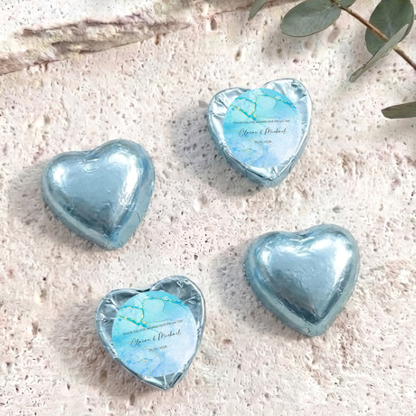 Foil-covered chocolate hearts in light blue with personalized blue label on top