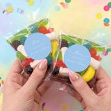 Two personalised lolly bags with assorted candies and blue Love sticker seals