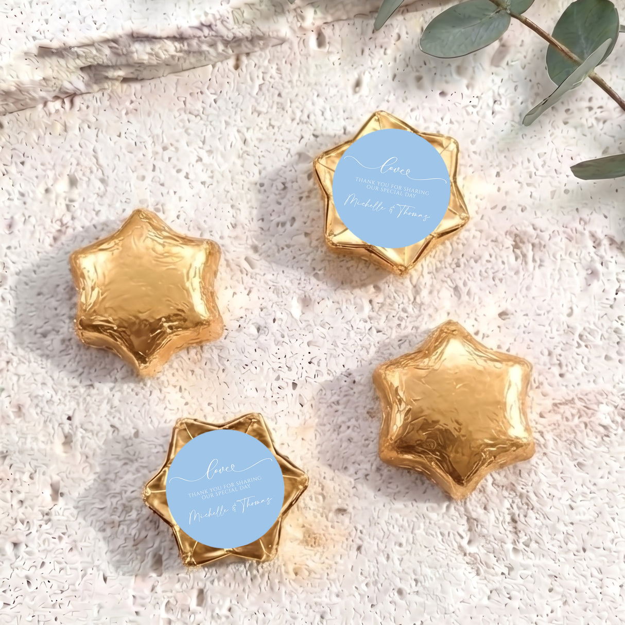 Gold foil-wrapped chocolate stars with round personalized label discs