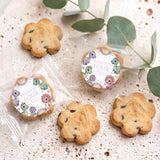 Dinosaur-themed personalized bite-size cookies with round toppers reading “Dolly is four”.