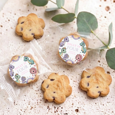 Dinosaur-themed personalized bite-size cookies with round toppers reading “Dolly is four”.