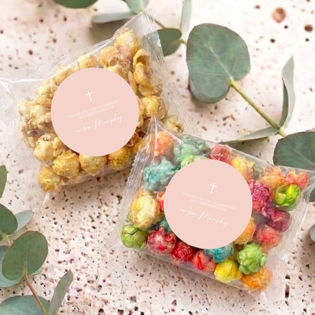 Personalised christening popcorn bags with pastel kernels in clear bags and round cross labels