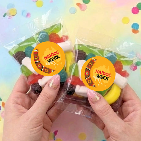 Two personalised lolly bags with NAIDOC Week stickers, clear wrappers with mixed sweets
