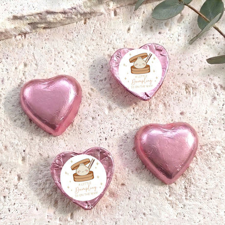 Pink foil-covered chocolate hearts with printed baby shower label