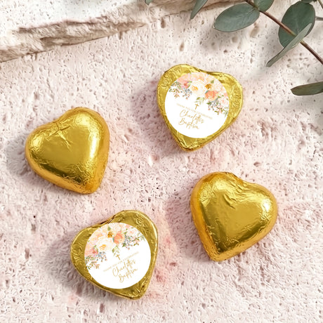 Gold foil-covered chocolate hearts with floral paper center and gold-toned trim