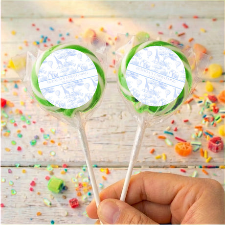 Personalised christening lollipop with green ribbon edge, two wrapped lollipops held by hand