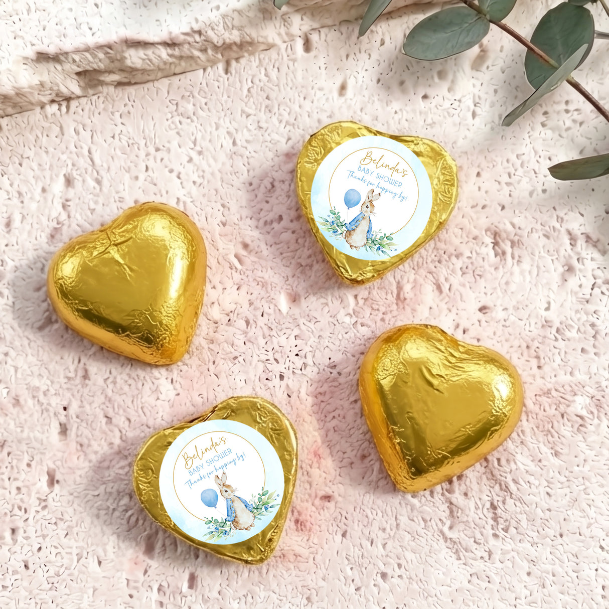 Gold foil-covered chocolate hearts with baby shower labels and bunny artwork