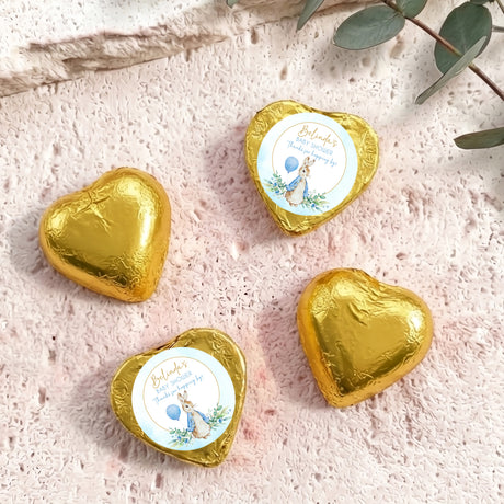 Gold foil-covered chocolate hearts with baby shower labels and bunny artwork