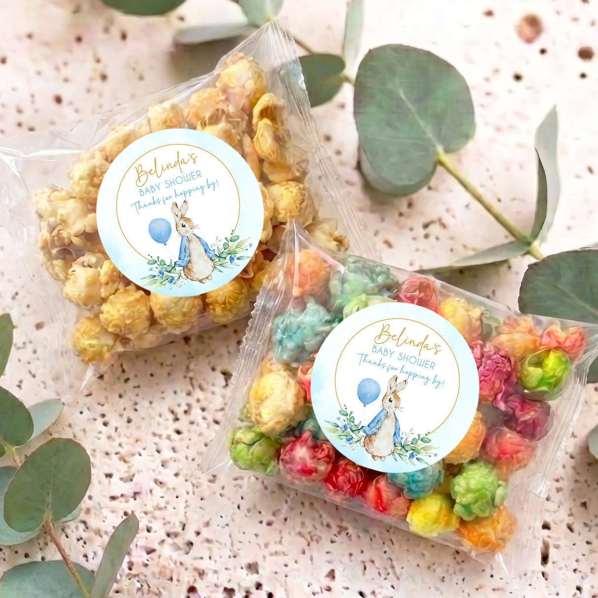 Two baby shower popcorn bags with bunny labels; clear bags of mixed pastel popcorn