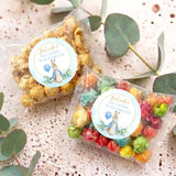 Two baby shower popcorn bags with bunny labels; clear bags of mixed pastel popcorn