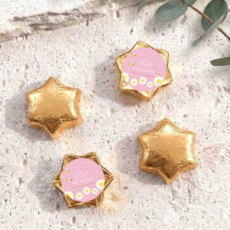 Gold foil-covered chocolate stars with “Dolly’s First Birthday” pink bee label
