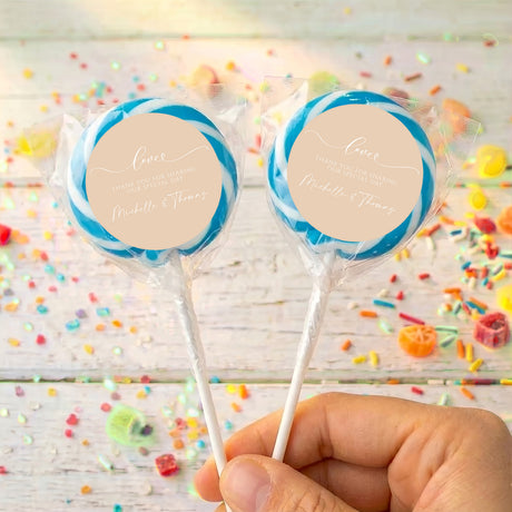 Personalised wedding lollipops with blue swirl tops and beige thank-you labels