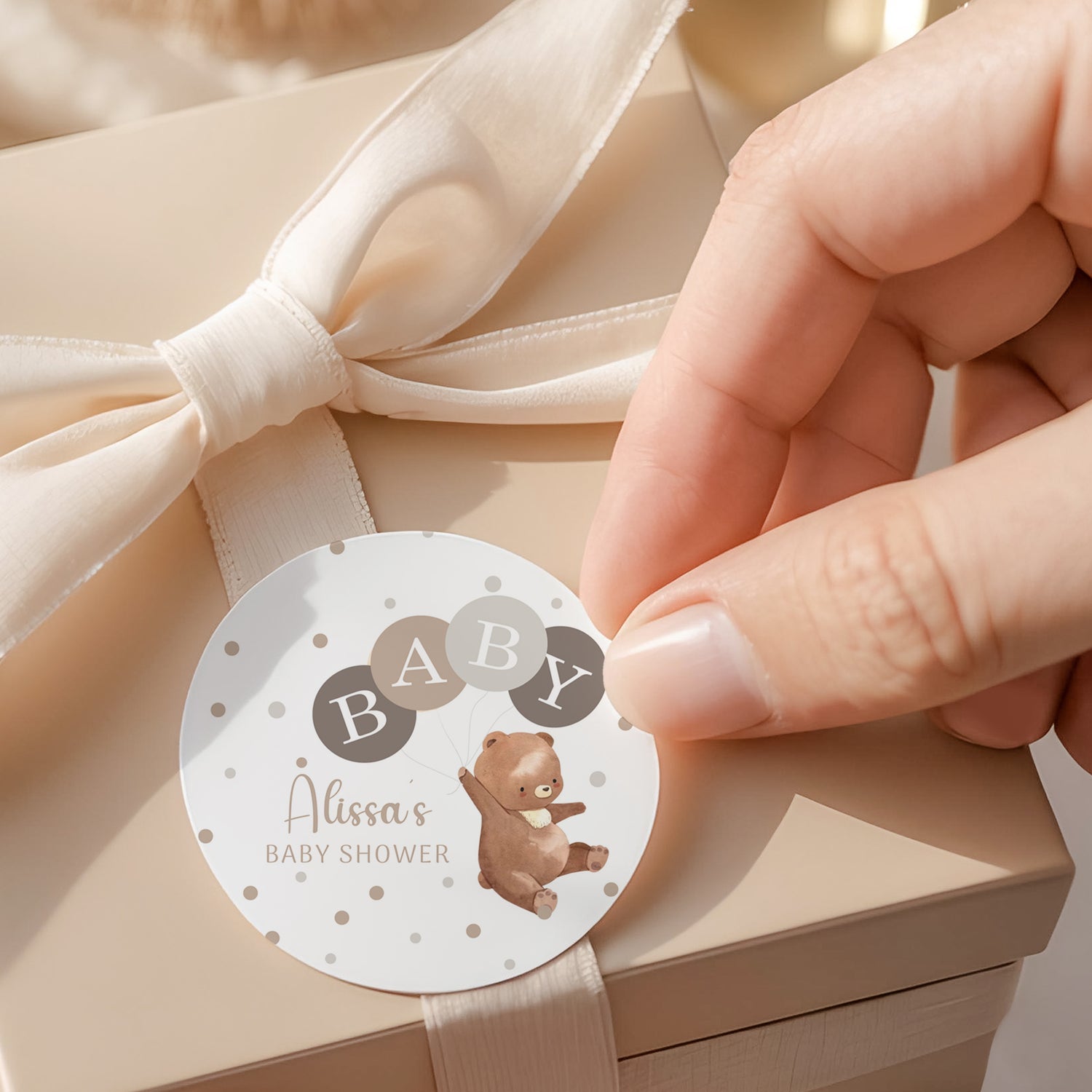 Round baby shower printed label with teddy bear illustration, dotted border, and BABY letters