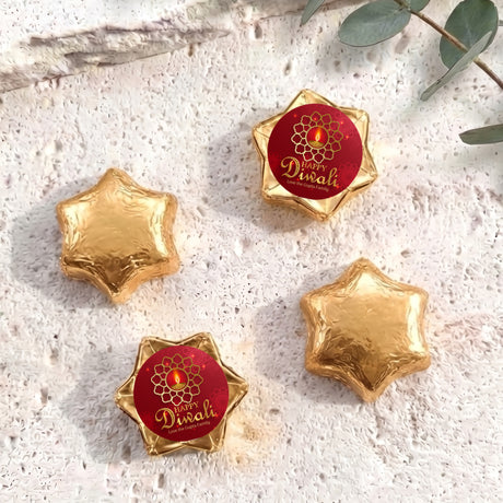 Foil-covered chocolate star sweets: gold stars with one red Diwali foil piece.