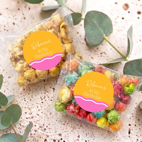 Two personalised birthday popcorn bags with clear wrap and yellow name labels on display