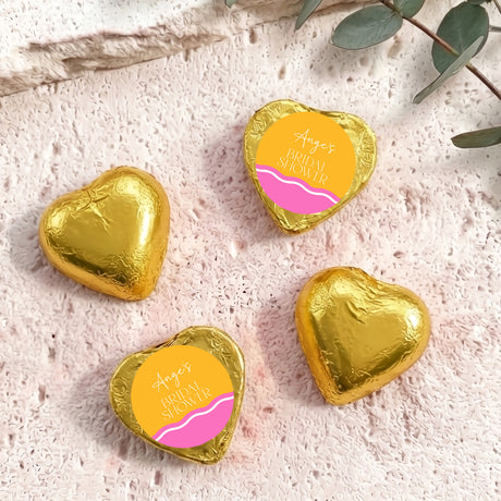 Gold foil-covered chocolate heart chocolates with personalized label, heart shape.
