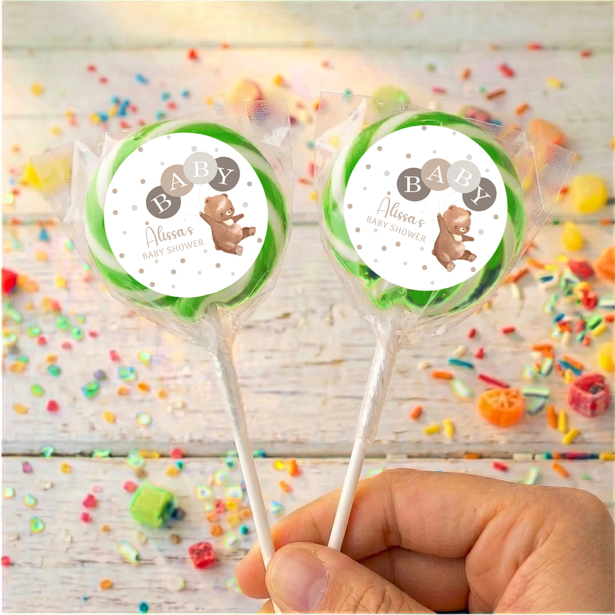 Baby shower personalised lollipops with green round label, clear wrapper, plain sticks