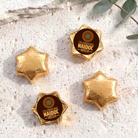 Foil-covered chocolate stars in gold tones, with NAIDOC WEEK label star topper
