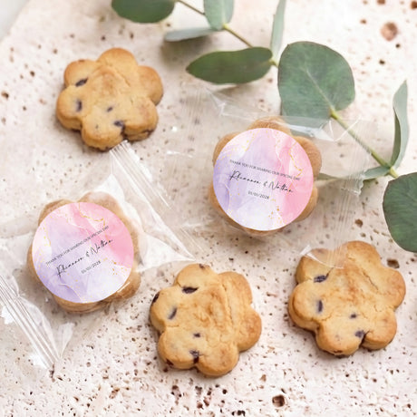 Four bite-size chip cookies with round pink marbled labels in clear wrap