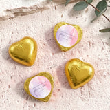 Foil-covered chocolate heart in gold with round white name label and crimped foil