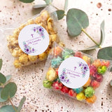 Personalised popcorn bags with clear wrap and colorful popcorn, purple floral confirmation stickers