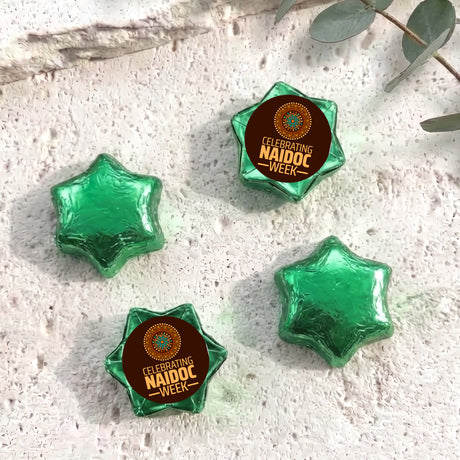 Foil-covered chocolate stars in green tones, with NAIDOC WEEK label star topper