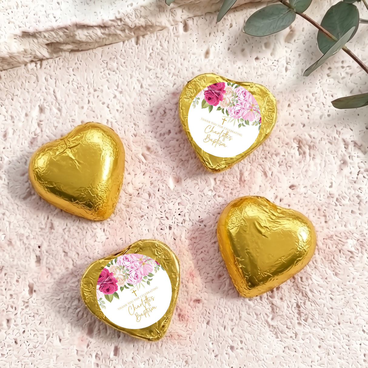 Heart-shaped foil-covered chocolate hearts in gold, with floral center labels