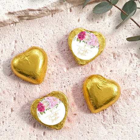 Heart-shaped foil-covered chocolate hearts in gold, with floral center labels