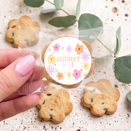 Personalised chocolate chip cookie with round 'AUDREY' label, held by hand