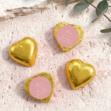 Gold heart-shaped foil-covered chocolates with a round pink label on top