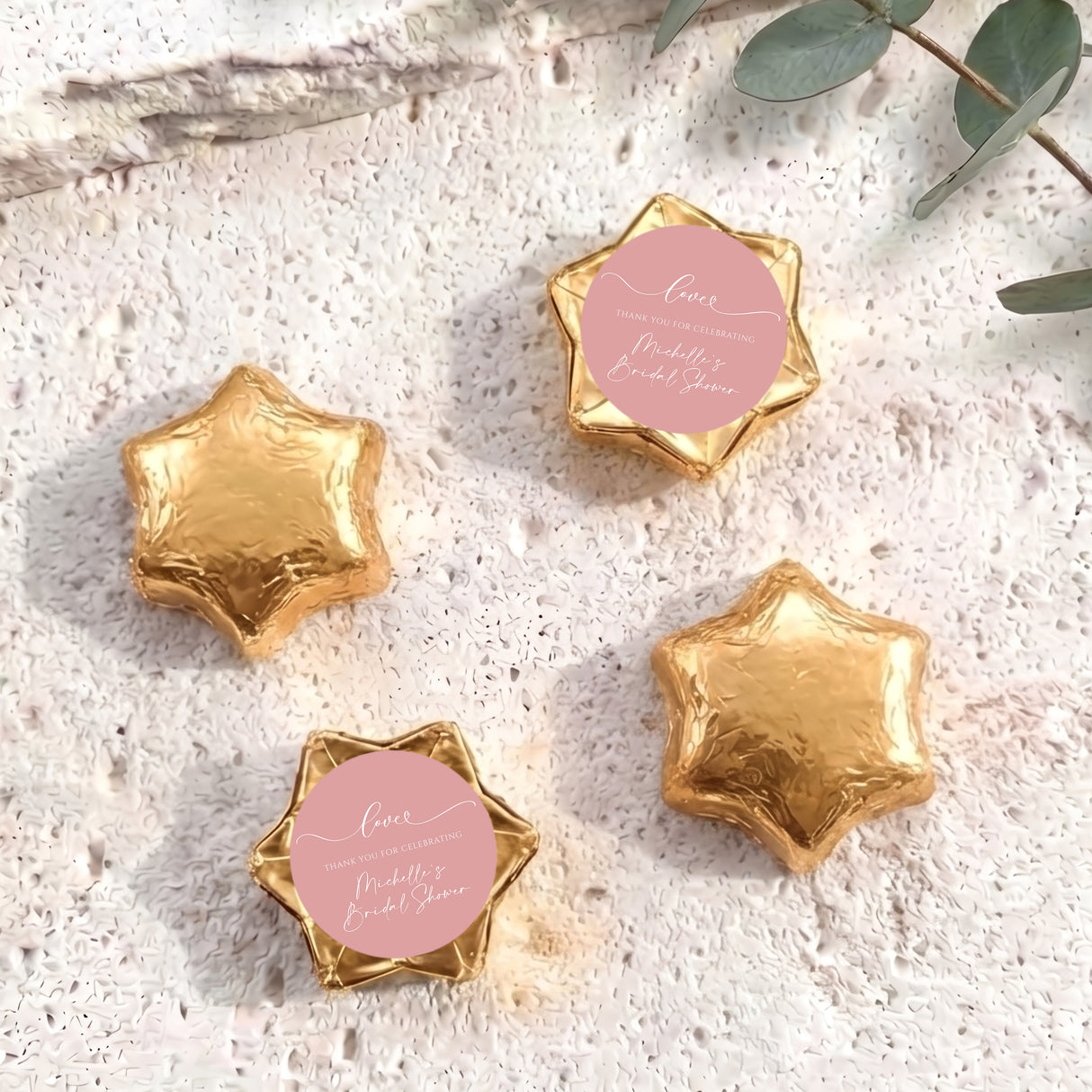 Set of gold foil-covered chocolate stars with a pink heart label