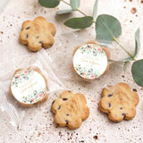 Assorted chocolate chip cookies with round floral labels, displayed on a tray