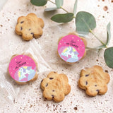 Assorted choc chip cookies in clear sleeves, each with pink unicorn birthday sticker
