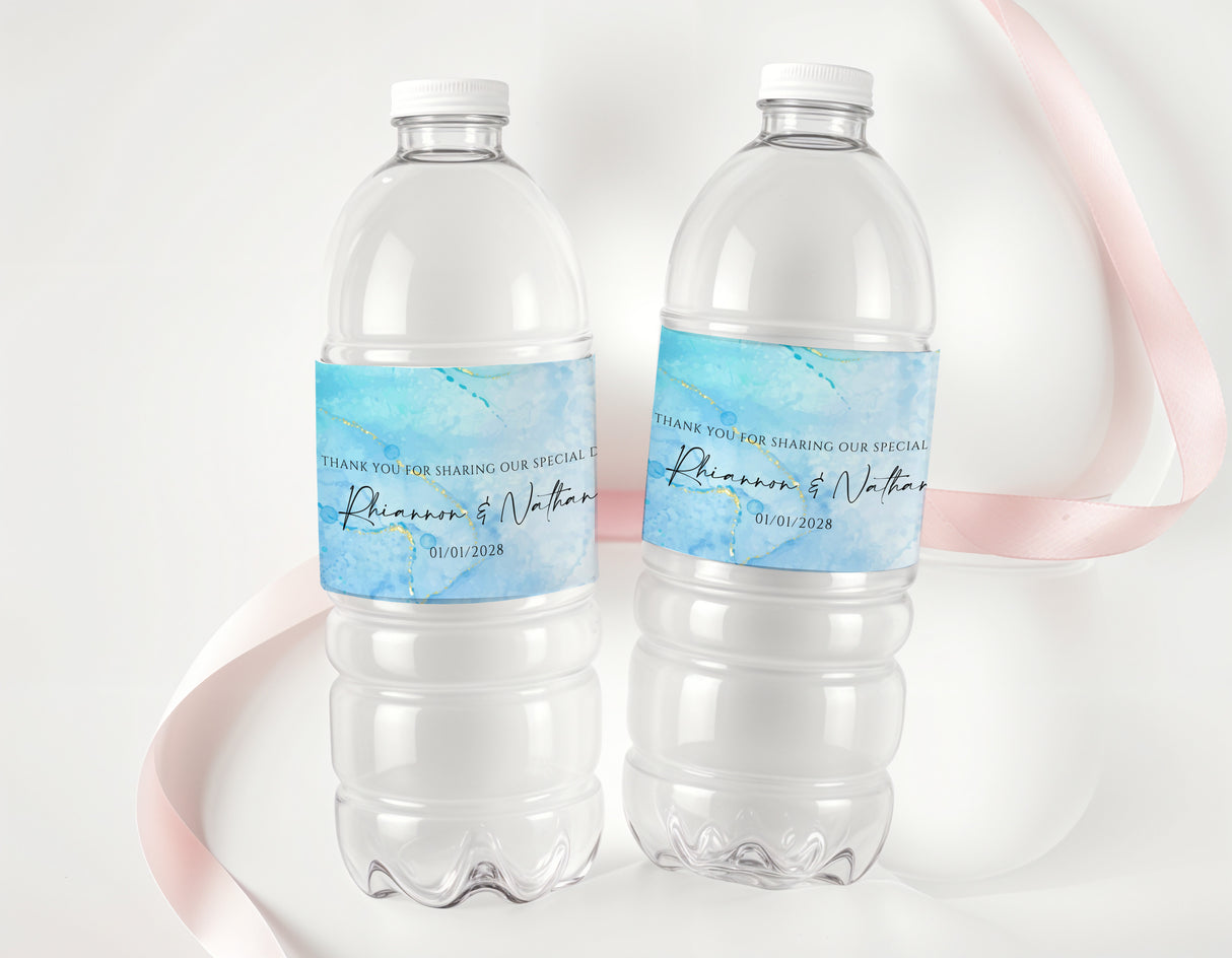 Two clear plastic water bottles with blue ink personalized labels and handwritten names/date