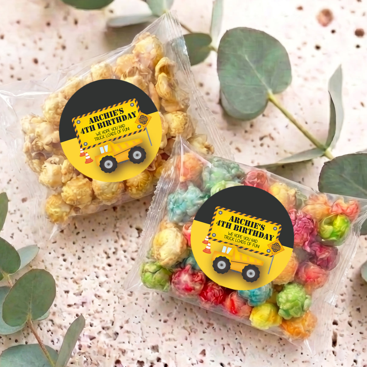 Personalised popcorn bags with yellow birthday stickers and mixed-color popcorn pieces