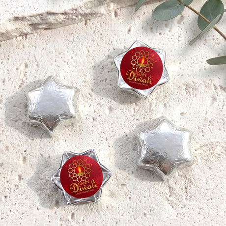 Foil-covered chocolate star sweets: silver stars with one red Diwali foil piece.