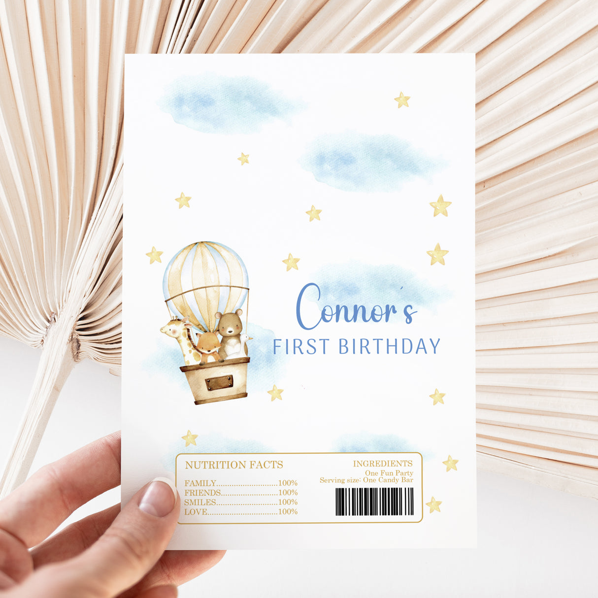First birthday chocolate wrapper with hot air balloon animals, stars, blue clouds, and Connor's text