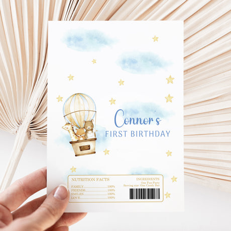 First birthday chocolate wrapper with hot air balloon animals, stars, blue clouds, and Connor's text